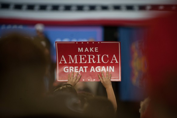 epa05936318 A supporter of US President Donald J. Trump holds up a &#039;Make America Great Again&#039; banner during a rally at the Pennsylvania Farm Show Complex in Harrisburg, Pennsylvania, USA, 29 ...