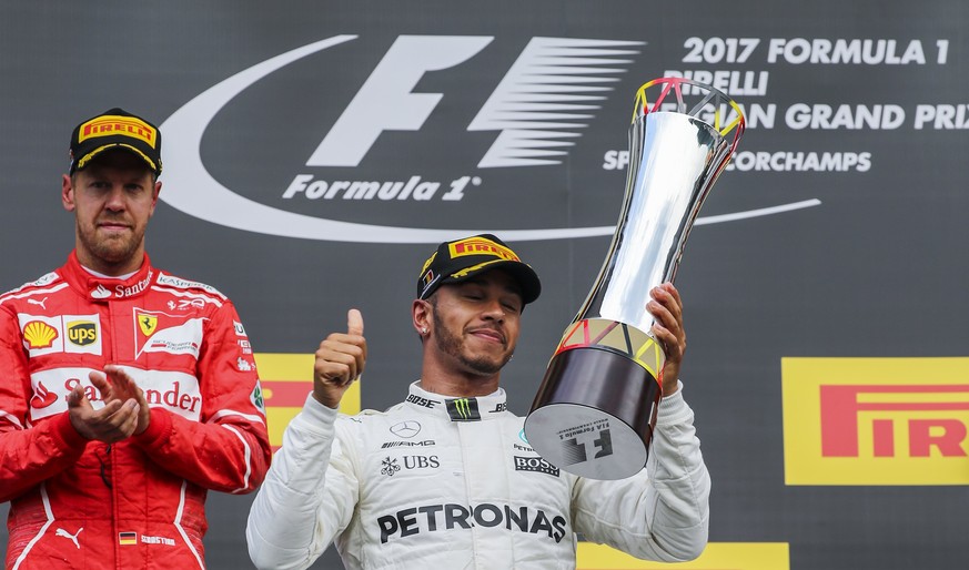 epa06166313 The winner, British Formula One driver Lewis Hamilton (C) of Mercedes AMG GP celebrates on the podium next to second placed German Formula One driver Sebastian Vettel (L) of Scuderia Ferra ...