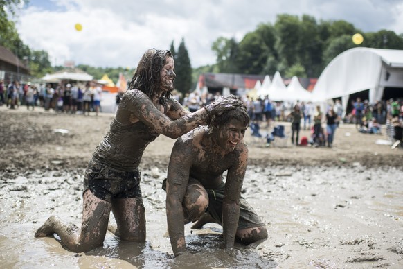 epa06059688 Visitors play in a puddle during the 41st Openair St. Gallen music festival, in St. Gallen, Switzerland, 01 July 2017. The festival runs until 02 July. EPA/ENNIO LEANZA