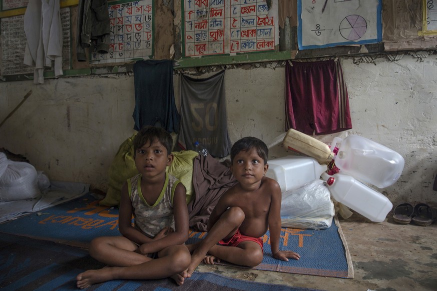 A Rohingya girl Tasleema Begum, left, and her sister Senuara Begum wait for their mother who has gone to get her family registered, after which they will be allowed to build a shelter in Kutupalong re ...