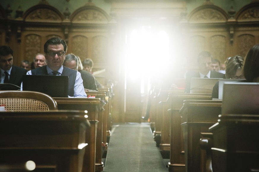 Corrado Pardini (SP-BE, links) arbeitet an seinem Pult im Nationalrat, waehrend der Wintersession der Eidgenoessischen Raete, am Dienstag, 15. Dezember 2015 in Bern. Die Sonne scheint hell durch die T ...