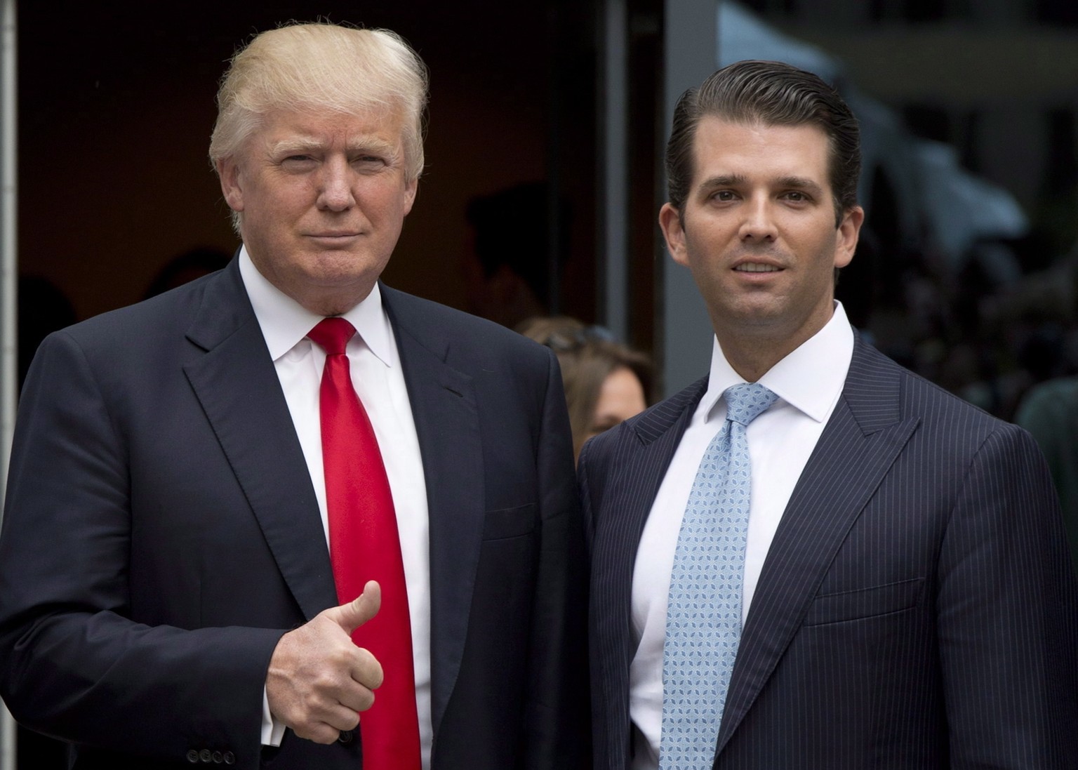 In this June 19, 2013 photo, Donald Trump, center, gives the thumbs up as he arrives with son Donald Trump Jr., daughter Ivanka Trump and Joo Kim Tiah, CEO and president of Holborn Group, to announce  ...