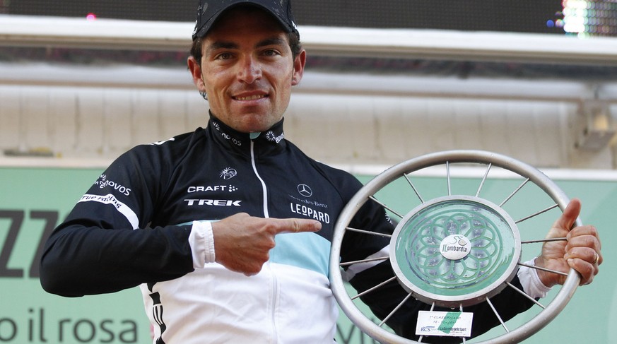 Oliver Zaugg of Switzerland shows his trophy on the podium after winning the Tour of Lombardy cycling race in Lecco, Italy, Saturday, Oct.15, 2011. (AP Photo/Luca Bruno)