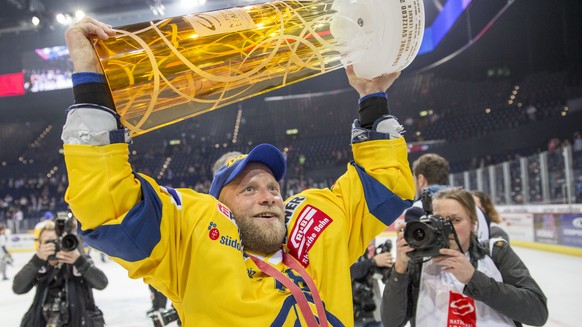 HC Davos Verteidiger Jan von Arx stemmt den Meisterpokal in die Hoehe und feiert mit den Fans den Titelgewinn nach ihrem Sieg im fuenften Playoff Finalspiel der National League A zwischen den ZSC Lion ...