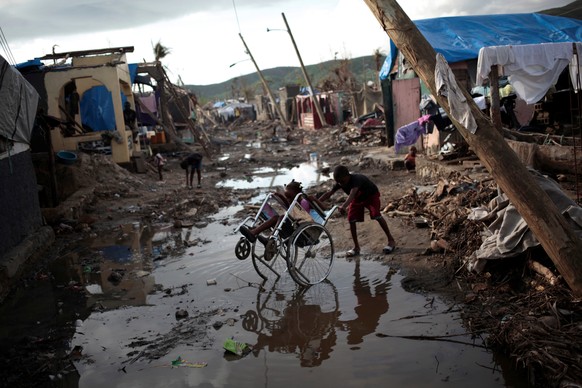 Two children play with a wheelchair in a street after Hurricane Matthew in Damassins, Haiti, October 22, 2016. REUTERS/Andres Martinez Casares