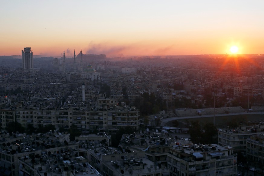 The sun rises while smoke is pictured near Aleppo&#039;s historic citadel, as seen from a government-controlled area of Aleppo, Syria December 6, 2016. REUTERS/Omar Sanadiki