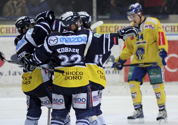 Ambri Spieler, links, feiern ihren 3:0 Sieg vor dem geschlagenen Langenthaler Claudio Cadonau, hinten rechts, nach dem fuenften Eishockey Auf-/Abstiegsspiel der National League A - National League B z ...