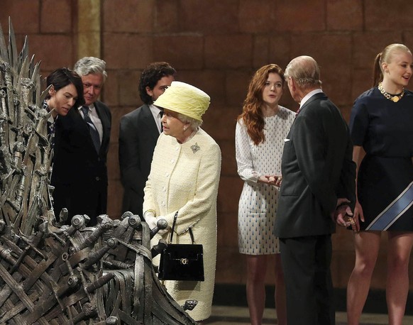 Britain&#039;s Queen Elizabeth looks at the Iron Throne as Prince Philip (2nd R) greets cast member Rose Leslie (3rd R) on the set of the television series Game of Thrones, in the Titanic Quarter of B ...