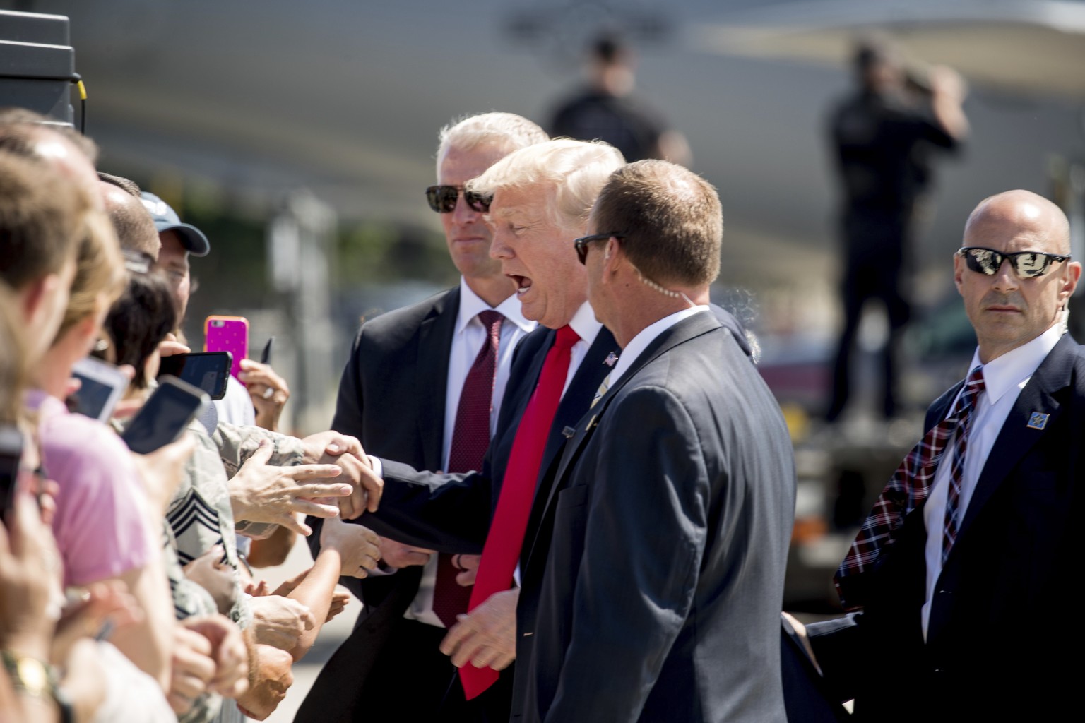 President Donald Trump greets guests on the tarmac after he arrived on Air Force One at General Mitchell International Airport in Milwaukee, Wis., Tuesday, June 13, 2017. (AP Photo/Andrew Harnik)