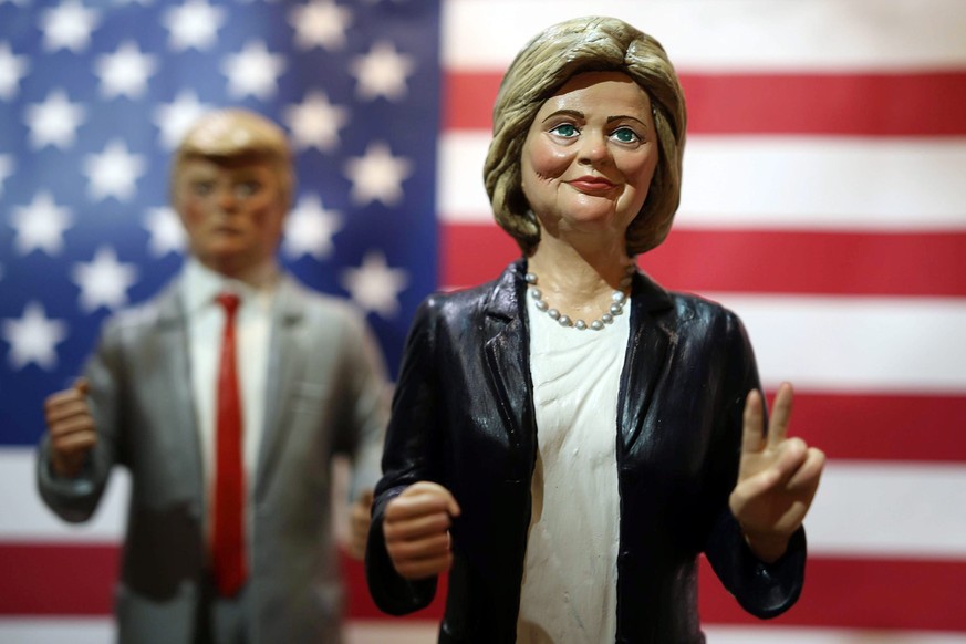 epa05590127 Figurines depicting US Presidential candidates Hillary Clinton (R), of the Democrats, and Donald Trump (L), of the Republican Party, are prepared to be arranged within the traditional &#03 ...