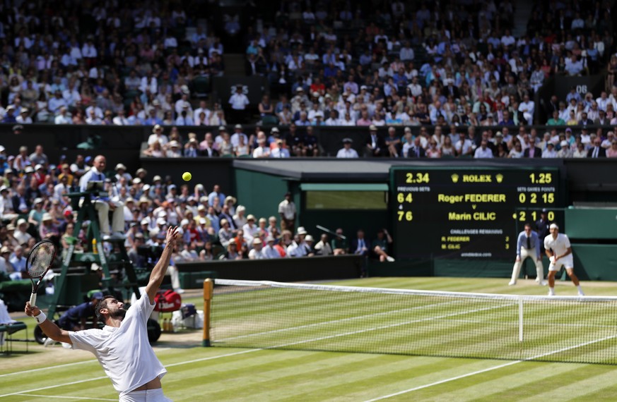 Marin Cilic of Croatia, bottom, serves to Roger Federer of Switzerland during their men&#039;s singles match on day ten of the Wimbledon Tennis Championships in London, Wednesday, July 6, 2016. (AP Ph ...
