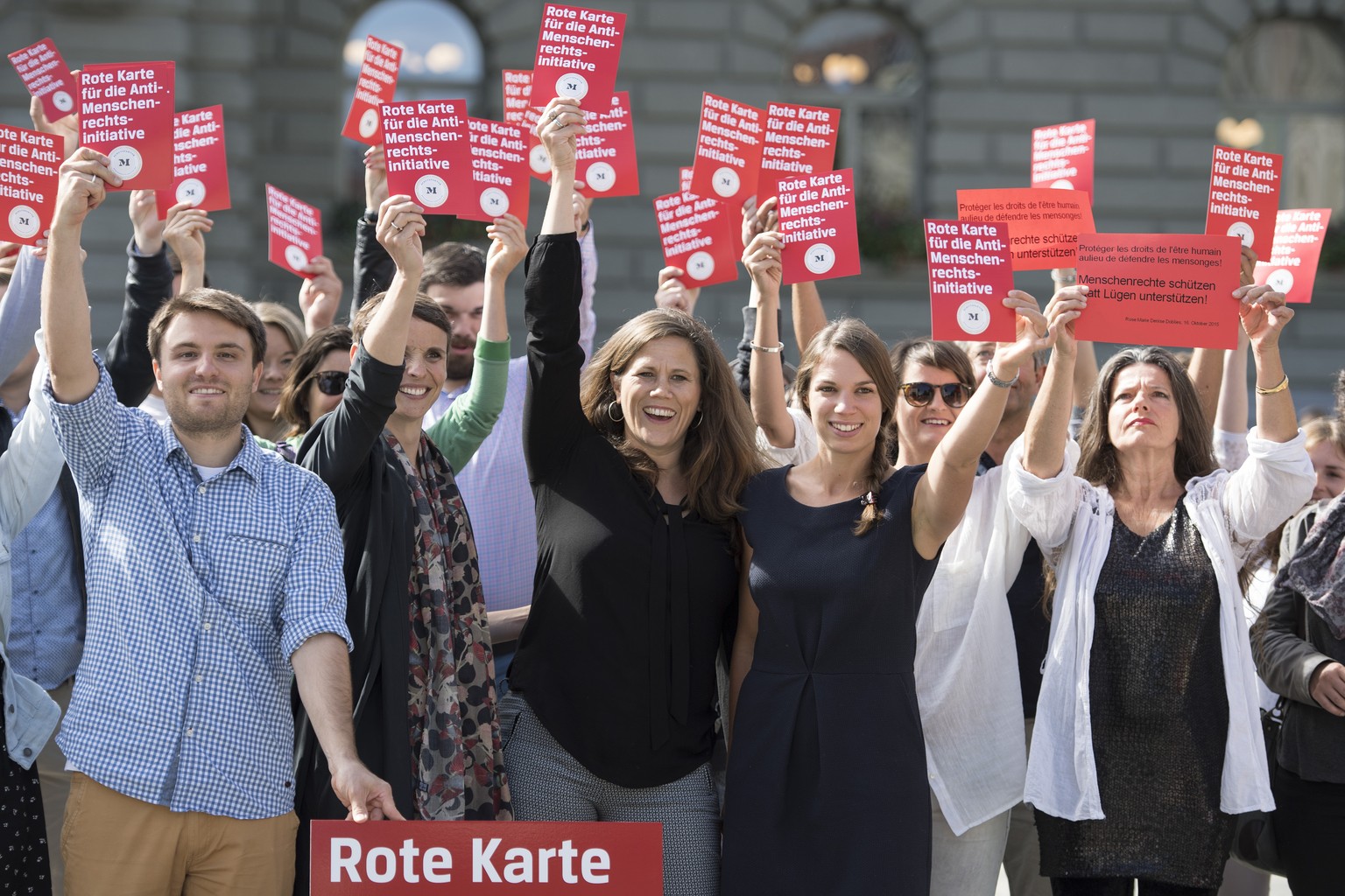 Mitglieder der NGO-Koalition &quot;Schutzfaktor M&quot;, mit Andrea Huber, Geschaeftsleiterin, Mitte, und Claudine Essevia, Beiraetin, links, zeigen die rote Karte an einer Aktion gegen die Selbstbest ...