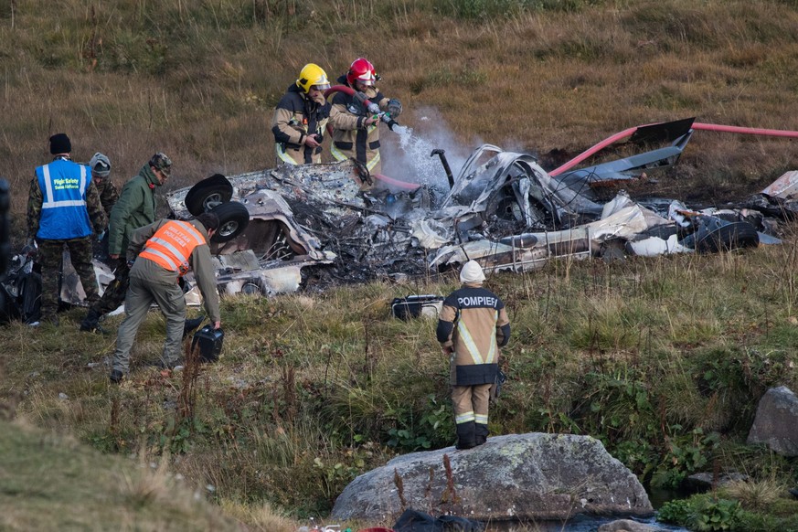 epa05560428 Firefighters extinguish the last flames on the debris from a crashed Swiss army helicopter of the tipe Super Puma near the fort Sasso da Pigna near the Gotthard mountain pass in Airolo, so ...