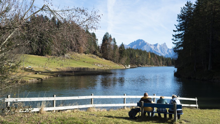 Menschen geniessen das Wetter am Chapfensee auf 1030 Meter ueber Meer, mit Blick auf Falknis, Schwarzhorn und Glegghorn, am Donnerstag, 12. November 2015, in Mels. (KEYSTONE/Gian Ehrenzeller)