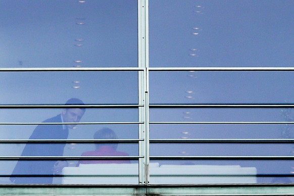 Former French Economy Minister and candidate for the next presidential election, Emmanuel Macron, left, takes his seat next to German Chancellor Angela Merkel during a meeting at the chancellery in Be ...