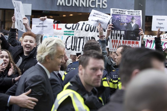 epa05843143 Geert Wilders (3-L) of the Dutch PVV Party is protected by security men against demonstrators shouting slogans and carrying protest banners, as he meets with members of the public in Heerl ...