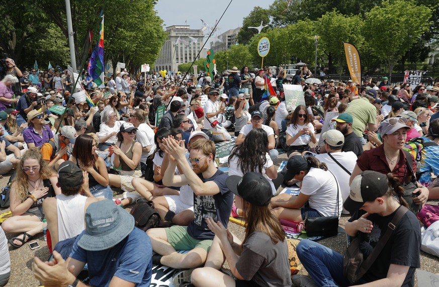 Demonstrators sit on the ground along Pennsylvania Ave. in front of the White House in Washington, Saturday, April 29, 2017, during a demonstration and march. Thousands of people gathered across the c ...