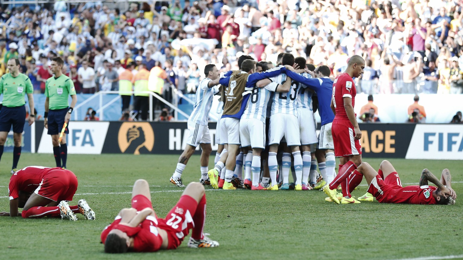 Switzerland&#039;s players lie on the ground while Argentina&#039;s players celebrate after the Round of 16 match between Switzerland and Argentina in the Arena de Sao Paulo in Sao Paulo, Brazil, Tues ...