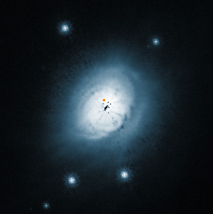 Diese Aufnahme des Hubble Space Telescope zeigt den Staub in den äusseren Bereichen des HD-100546-Systems im sichtbaren Licht. Die Position des neuentdeckten Protoplaneten ist markiert.
