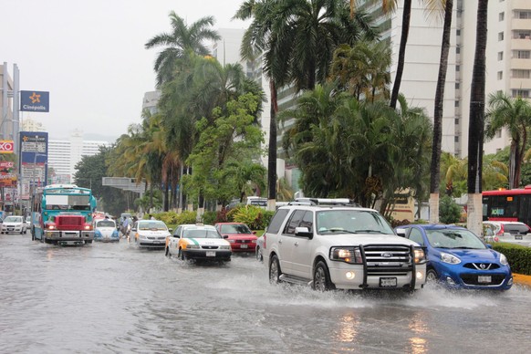 epa05460678 A general view shows vehicles transiting at a flooded street due to heavy rains left by Tropical Storm Earl&#039;s passage in Acapulco, Mexico, 06 August. Heavy rains spawned by Tropical S ...