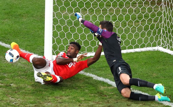 Switzerland&#039;s Johan Djourou vies for the ball with France goalkeeper Hugo Lloris during the Euro 2016 Group A soccer match between Switzerland and France at the Pierre Mauroy stadium in Villeneuv ...