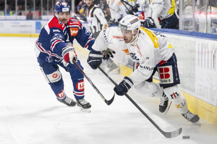 Nachrichten Linkding Justin Sigrist (ZSC) (links) kaempft um den Puck mit Tommaso De Luca (HCAP) (rechts) im Spiel der Eishockey National League zwischen ZSC Lions, ZSC, und HC Ambri-Piotta, HCAP, vom Freitag, 6. Dezember ...