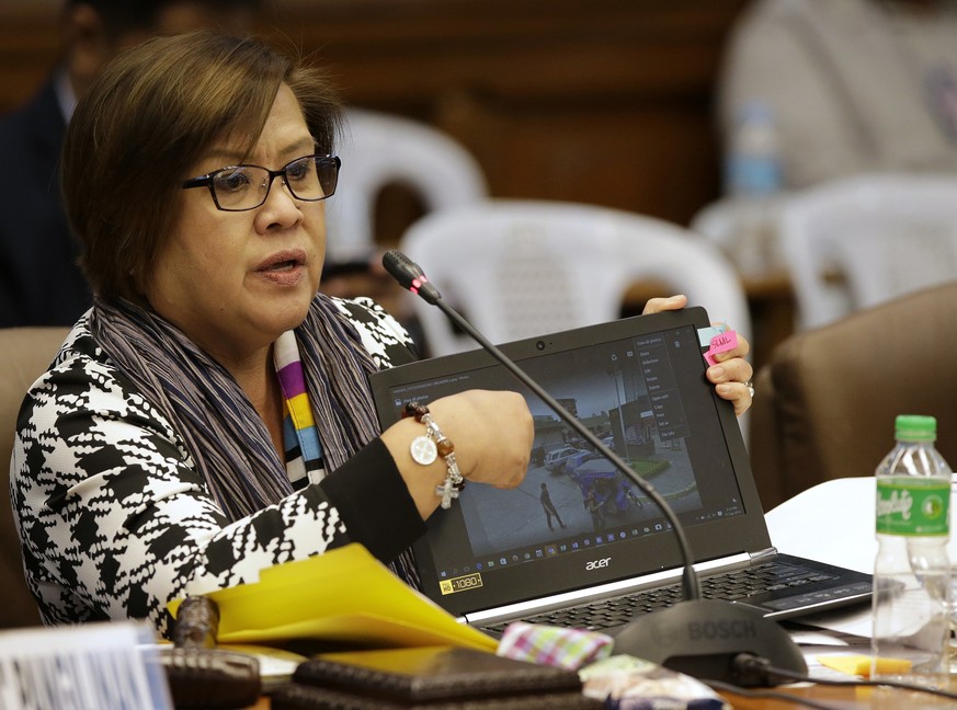 Philippine Senator Leila De Lima, Chairperson of the Committee on Justice and Human Rights, shows a picture on a laptop as former Filipino militiaman Edgar Matobato answers questions during his testim ...