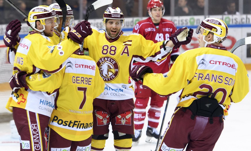 Les joueurs genevois laissent eclater leur joie apres le premier but devant la deception du defenseur lausannois John Gobbi, derriere droite, lors du match du championnat suisse de hockey sur glace de ...