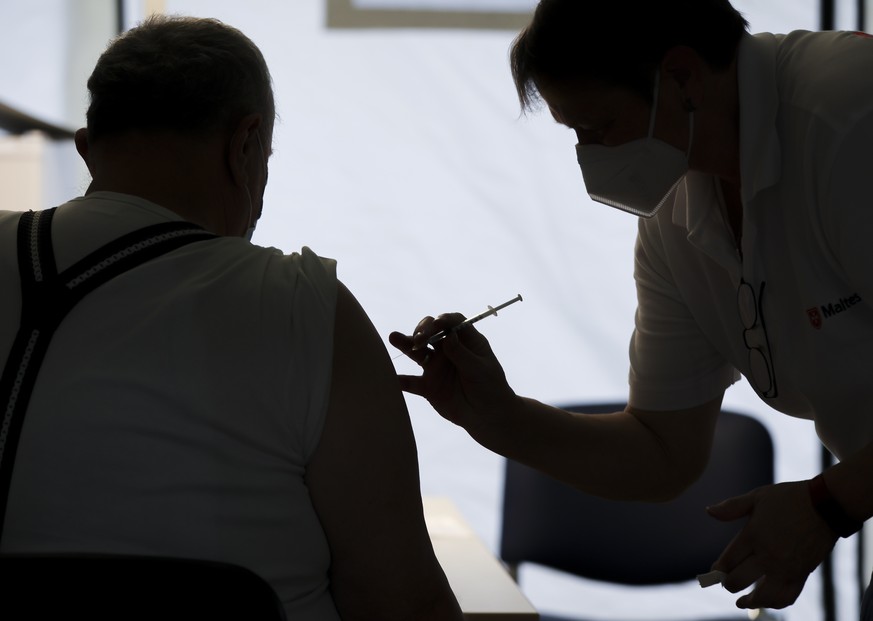 A Malteser employee vaccinates a citizen at the reopened vaccination centre in Luetzen, Germany, Monday, Nov. 22, 2021. The district had to close the center on October 1, now residents can again get a ...