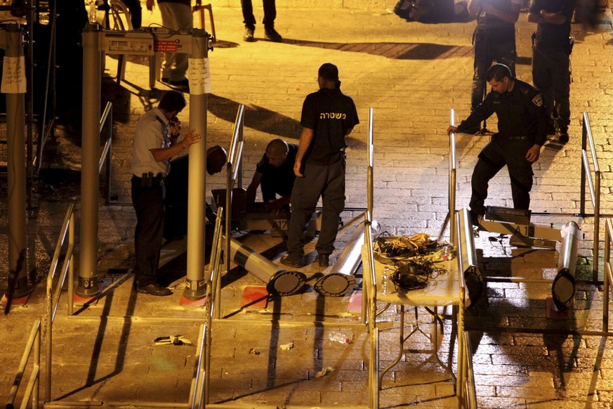 Israeli police officers dismantle metal detectors outside the Al Aqsa Mosque compound in Jerusalem&#039;s Old City, early Tuesday, July 25, 2017. Israel&#039;s security cabinet has decided to remove m ...