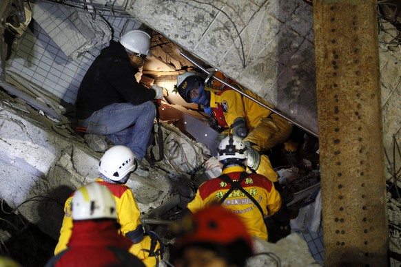 Rettungskräfte suchen in dem eingestürzten Gebäude in Tainan nach Vermissten: Mehr als 100 Personen werden noch in dem Hochhaus vermutet.