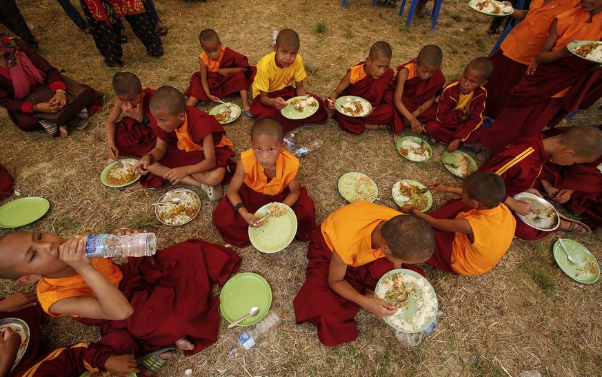 epa05952306 Nepalese Buddhist monks take lunch break during the foundation ceremony for the Mahasiddha Sanctuary for Universal Peace to mark Buddha&#039;s birthday at his birthplace in Lumbini, Nepal, ...