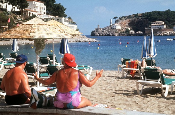 Touristen sitzen am Strand von Mallorca, undatierte Aufnahme. Mallorcas Straende locken mit ihrem weissen, feinkoernigen Sand und dem tiefblauen Meer jaehrlich Millionen von Touristen an. (KEYSTONE/EP ...