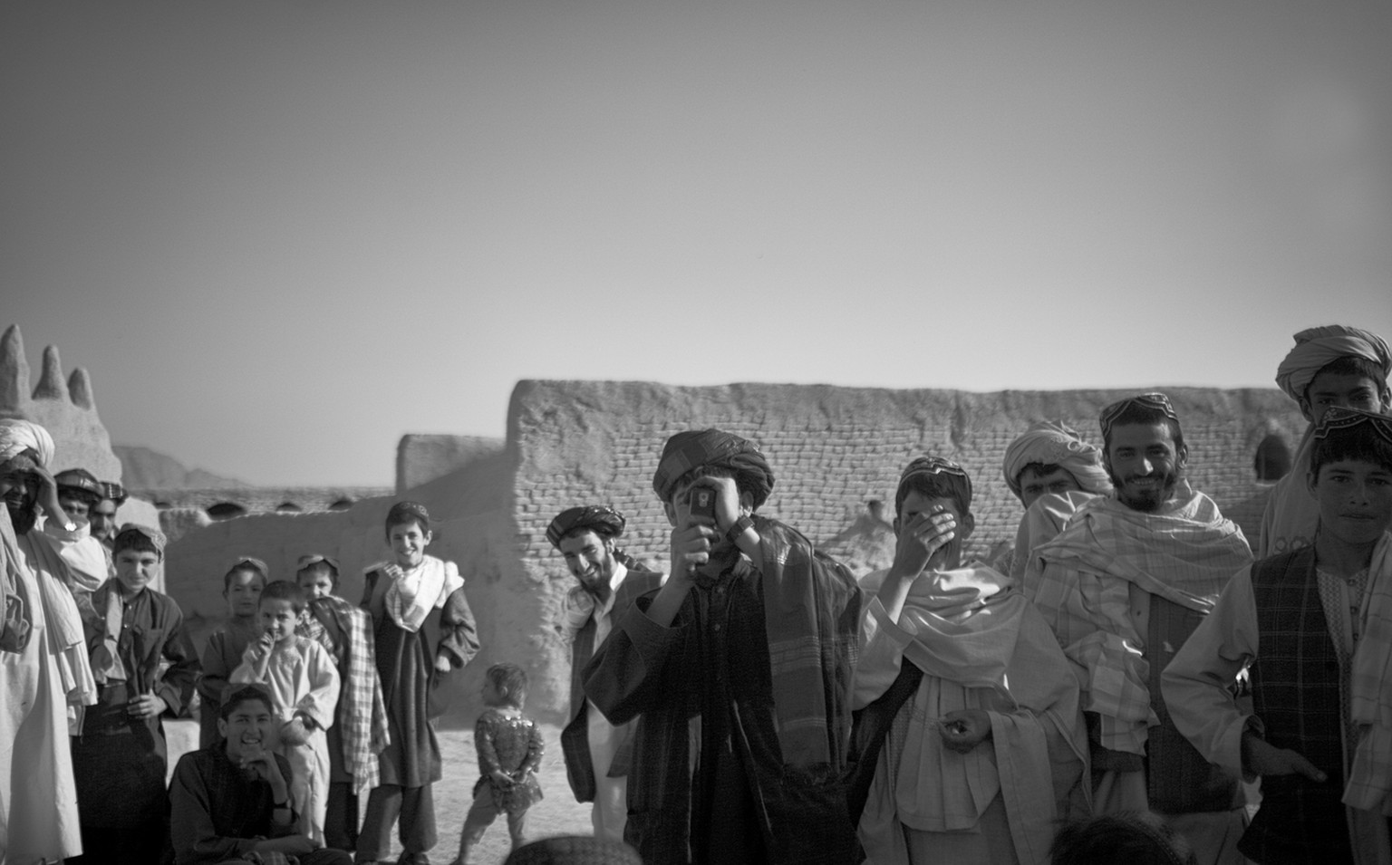 Salavat, Afghanistan, September 2010. Afghanische Männer fotografieren kanadische Soldaten des Royal Canadian Regiment auf ihrer Patrouille. Als die kanadische Patrouille kurz darauf das Dorf verlässt ...