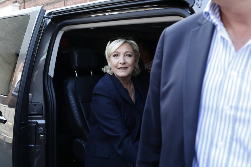 epa06034853 The candidate for the far-right Front National (FN) party, Marine Le Pen (L-2), leaves a polling station after casting her vote in the second round of French legislative elections in Henin ...