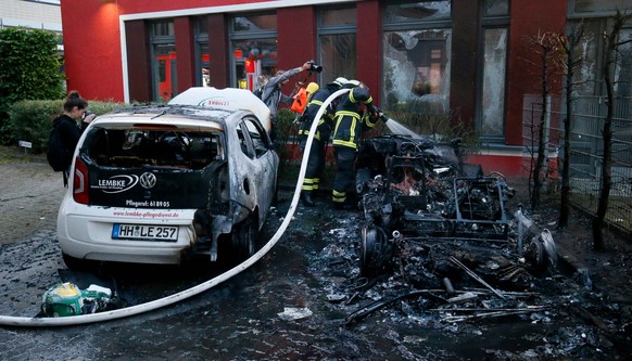 epa06071536 Firemen extinguish a car that was set alight during demonstrations ahead of the G20 summit in Hamburg, Germany, 06 July 2017. The G20 Summit (or G-20 or Group of Twenty) is an internationa ...