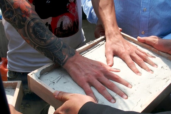 Soccer star Lionel Messi leaves his hand print in cement at the construction site of a new soccer stadium in Port-Gentil, Gabon, July 18, 2015. REUTERS/Gérauds Wilfried Obangome