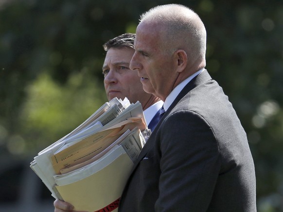 Director of Oval Office operations Keith Schiller, right, with White House doctor Ronny Jackson, carries documents as they walk to Marine One on the South Lawn of the White House in Washington, Friday ...