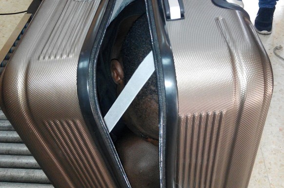 In this photo released by the Spanish Guardia Civil on Tuesday, Jan. 3, 2017, a 19 year-old migrant from Gabon is photographed in a suitcase, in Ceuta, Spain. Border guards have recently detained two  ...