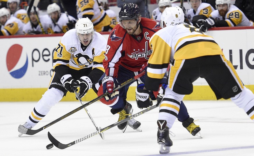 Washington Capitals left wing Alex Ovechkin, center, of Russia, chases the puck against Pittsburgh Penguins&#039; Evgeni Malkin (71), of Russia, and Brian Dumoulin, right, during the second period of  ...