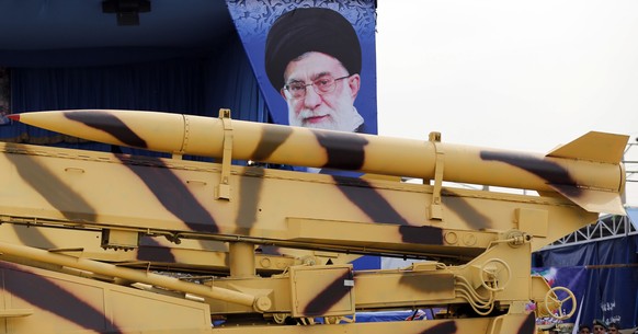 epa04171122 An Iranian mid-range missile &#039;Zelzal&#039; is driven by a huge poster of Iranian supreme leader Ayatollah Ali Khamenei during a ceremony marking the annual National Army Day in Tehran ...