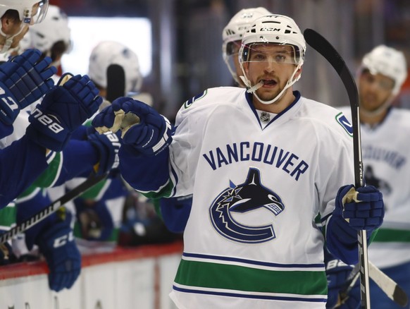 Vancouver Canucks left wing Sven Baertschi, of the Czech Republic, is congratulated as he passes the team box after scoring the go-ahead goal against the Colorado Avalanche during the third period of  ...