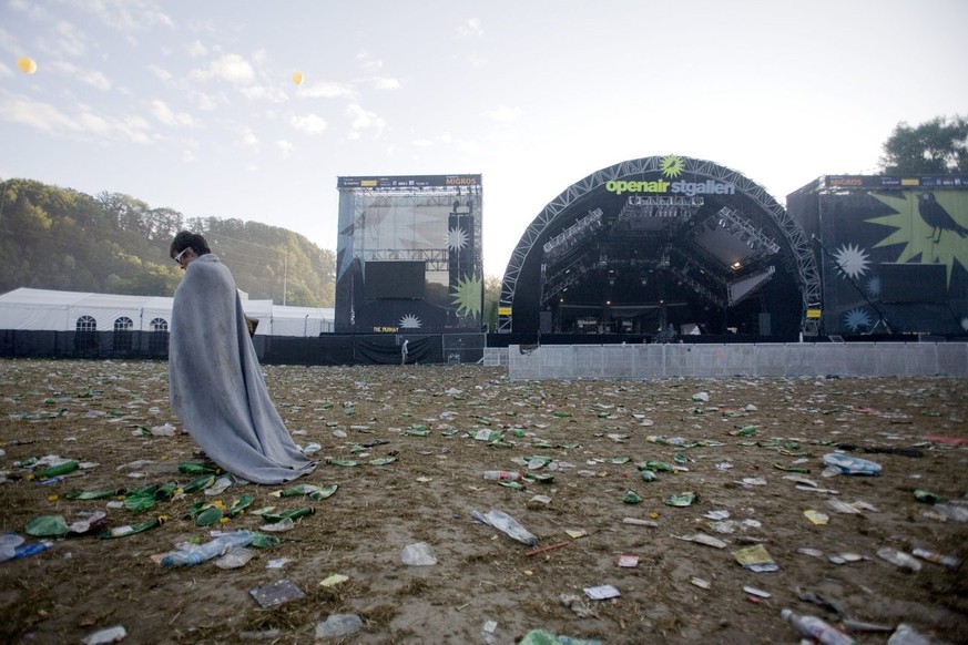 Ein Festivalbesucher torkelt verlassen ueber die mit Abfall ueberfuellte Wiese der Sitterbuehne am St. Galler Openair am fruehen Sonntagmorgen, 29. Juni 2008. Trotz tollem Festivalwetter ist das dreit ...