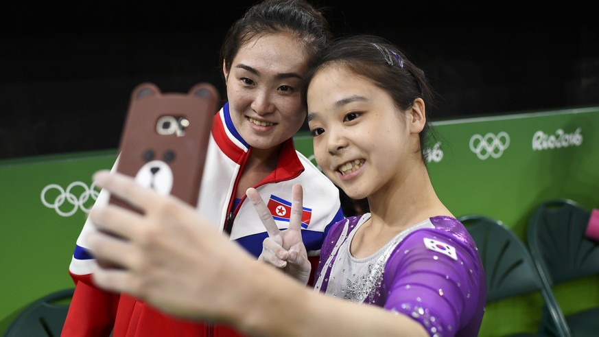 2016 Rio Olympics - Gymnastics training - Rio Olympic Arena - Rio de Janeiro, Brazil - 04/08/2016. Lee Goim (KOR) of South Korea (R) takes a selfie picture with Hong Un Jong (PRK) of North Korea. REUT ...