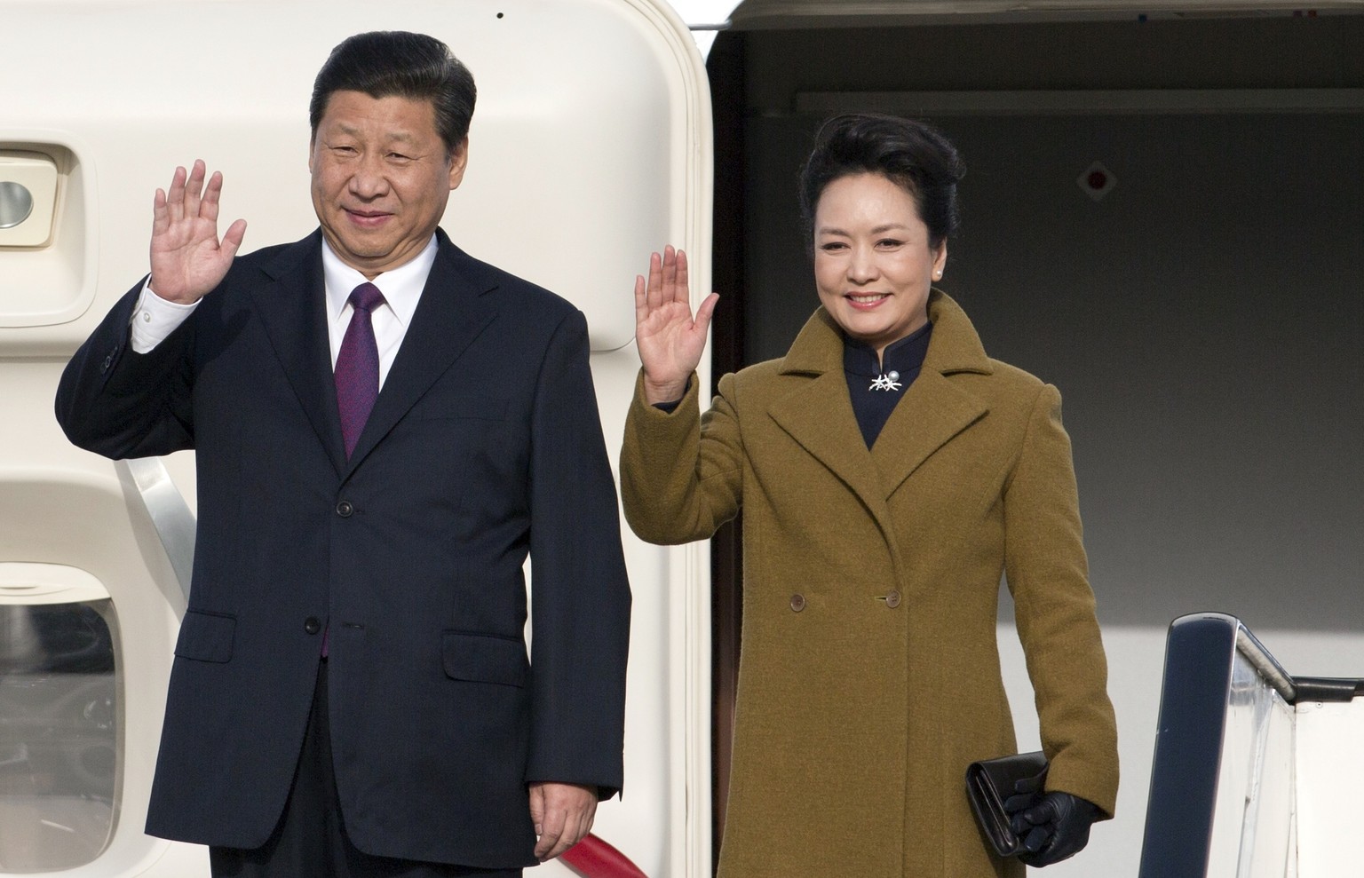 China&#039;s President Xi Jinping, left, and his wife Peng Liyuan wave as they arrive at Abelag airport in Brussels on Sunday, March 30, 2014. Xi is on a three-day official visit to Belgium. (AP Photo ...