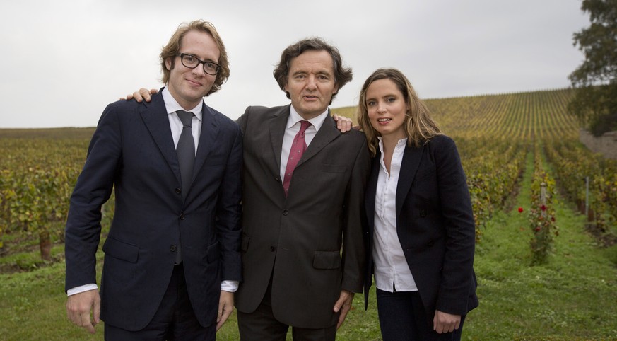 Pierre-Emmanuel Taittinger, center, stands with his son Clovis, left, and his daughter Vitalie in front of vineyards on his estate in Pierry, France on Thursday, Oct. 15, 2014. (AP Photo/Virginia Mayo ...