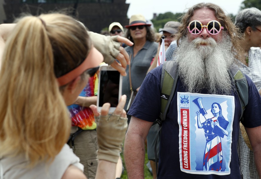 Craig Schwanke, from Asburn, Va., pauses as a woman takes his picture, during a rally to protest President Donald Trump and his policies, on the National Mall, Saturday, June 3, 2017, in Washington. ( ...