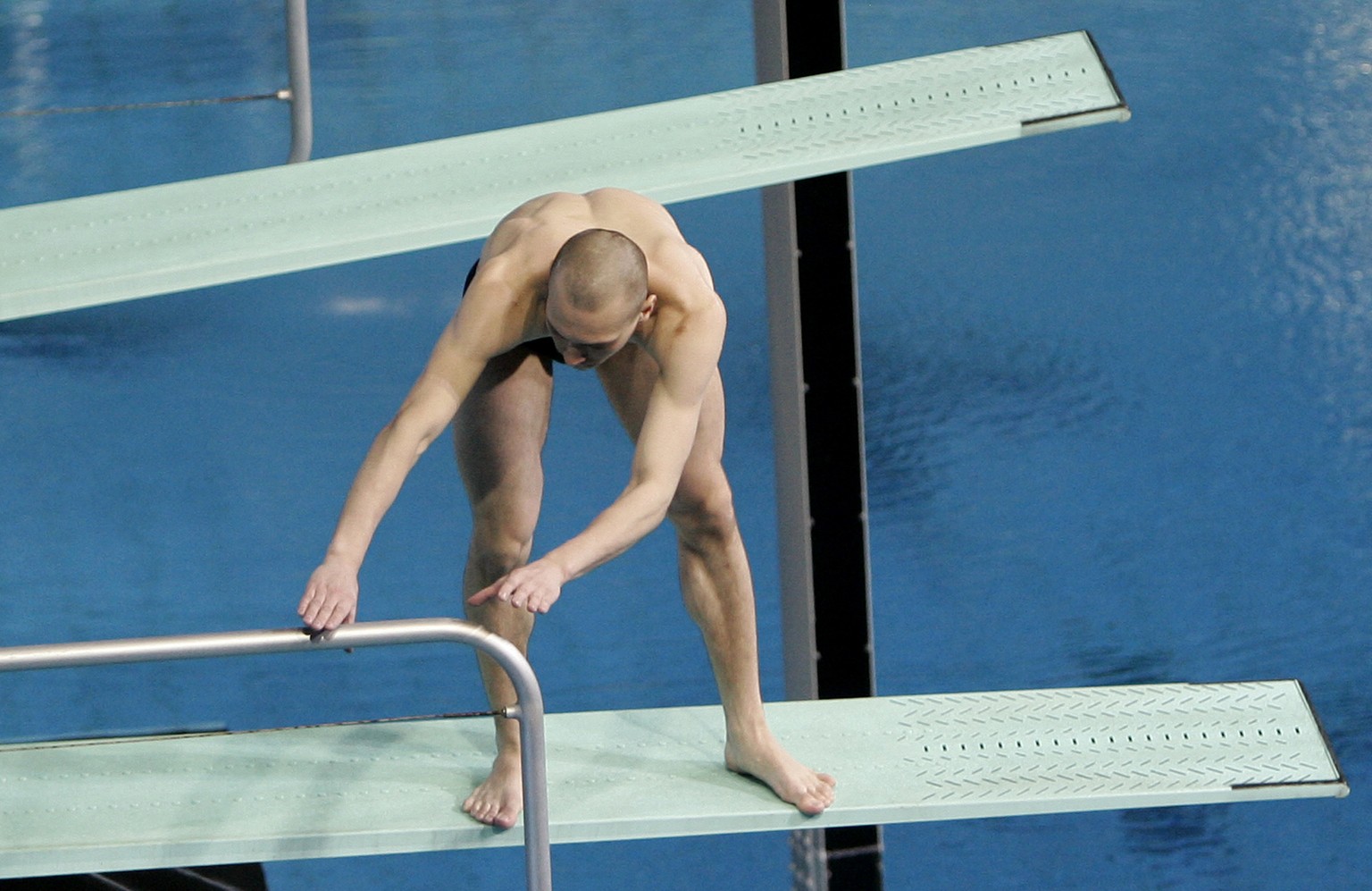 Russian diver Aleksandr Dobroskok grabs a rail after he failed to dive with his partner Gleb Galperin during the final of the men's 3-meter synchro springboard event at the World Swimming Champio ...