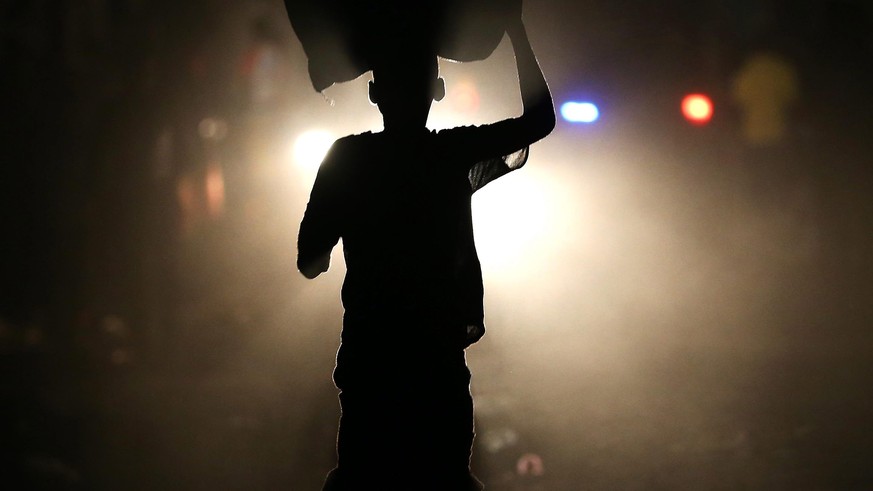 epa05581804 A man walks for a street without light due to a power failure in the wake of Hurricane Matthew in Jeremie, Haiti, 11 October 2016. The category 4 hurricane made landfall in the country on  ...