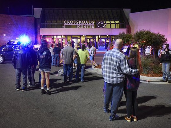 People stand near the entrance on the north side of Crossroads Center mall between Macy&#039;s and Target as officials investigate a reported multiple stabbing incident, Saturday, Sept. 17, 2016, in S ...
